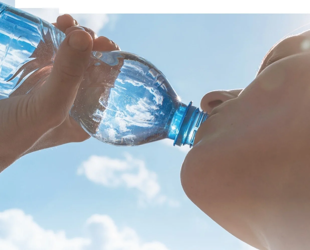 透明な水のボトルを持つ一対の手