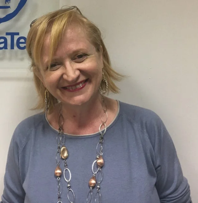 ネックレスをつけて微笑む女性